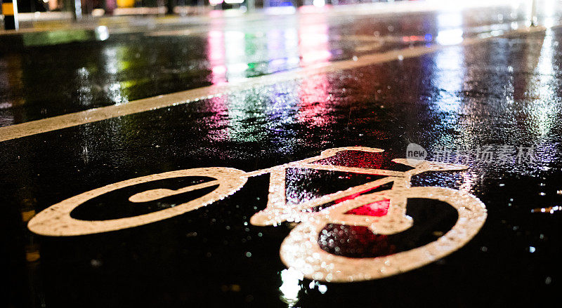 下雨天的自行车道。沥青上的自行车标志