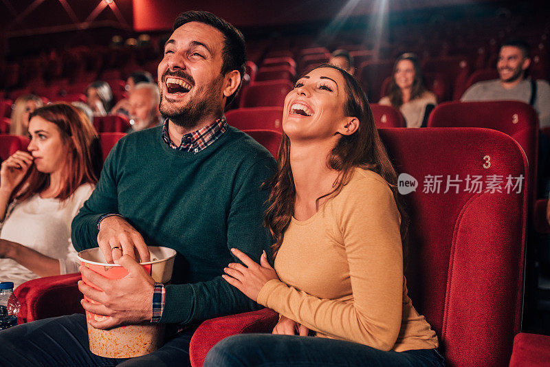 一对浪漫的情侣在电影院笑