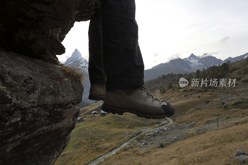 徒步旅行者把脚悬在边缘