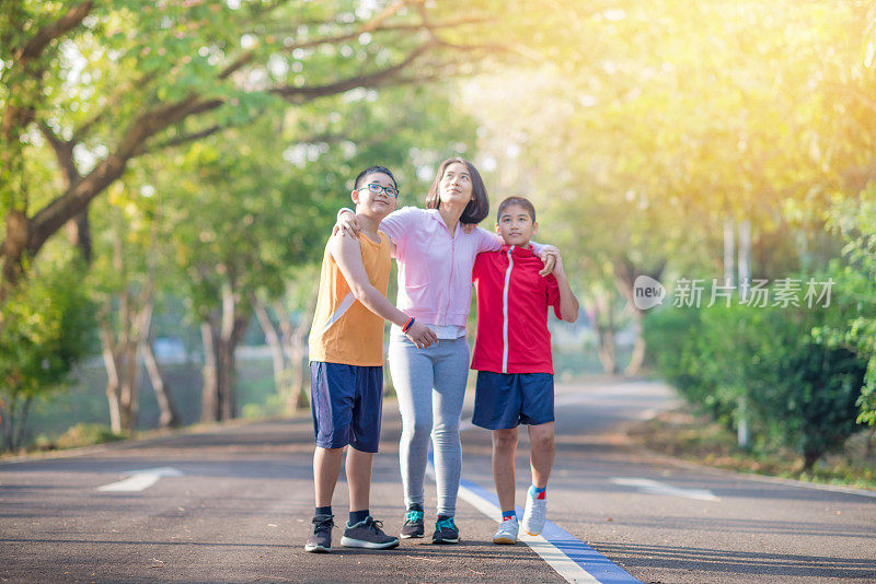 家庭运动快乐活跃的母亲和孩子在户外慢跑，在森林里跑步