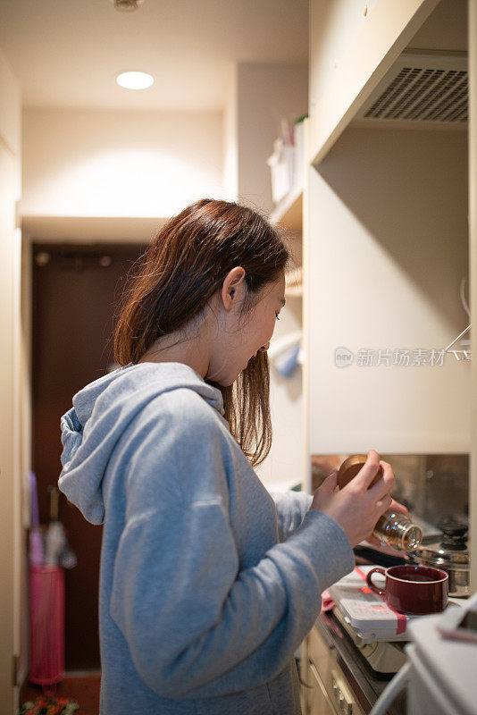 在厨房里煮咖啡的女人