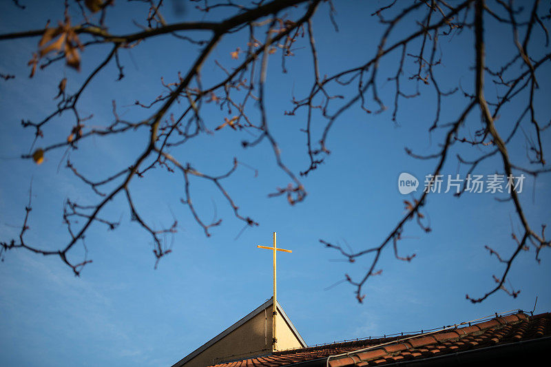 阳光下教堂上的金色十字架，德国