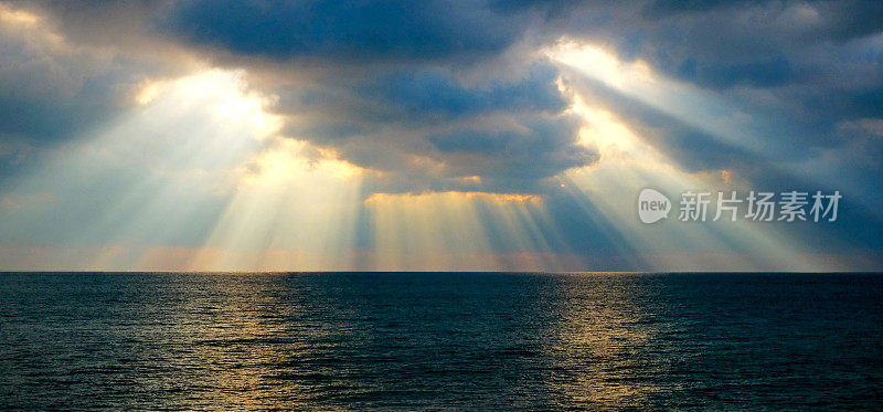 阳光穿过云层照在海面上