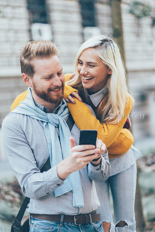 幸福的年轻夫妇使用智能手机