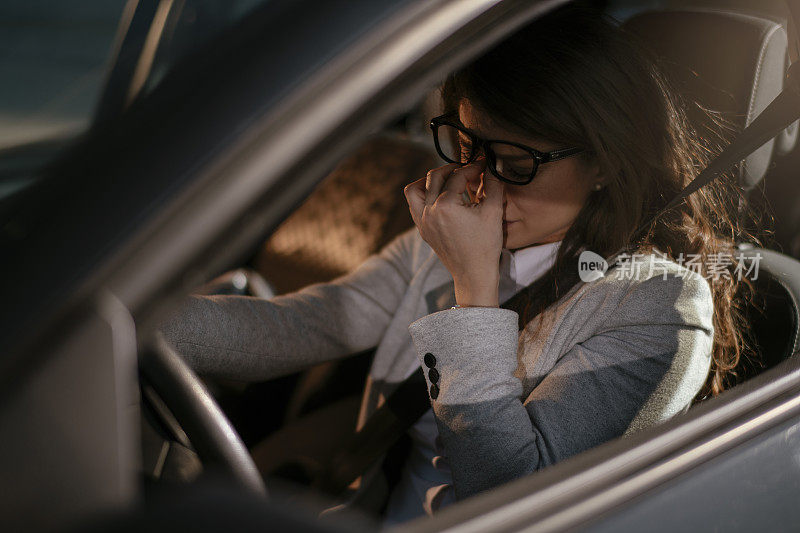 女商人开车累了昏昏欲睡的女商人开着她的车