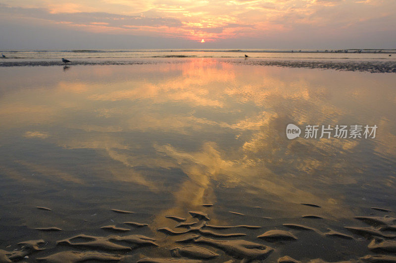 夏日海滩上的日落，海面平静