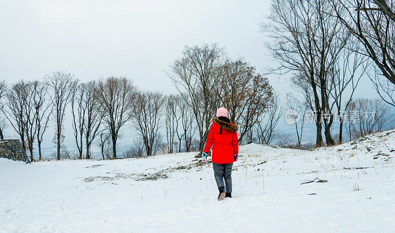 在白雪覆盖的森林里行走的女人