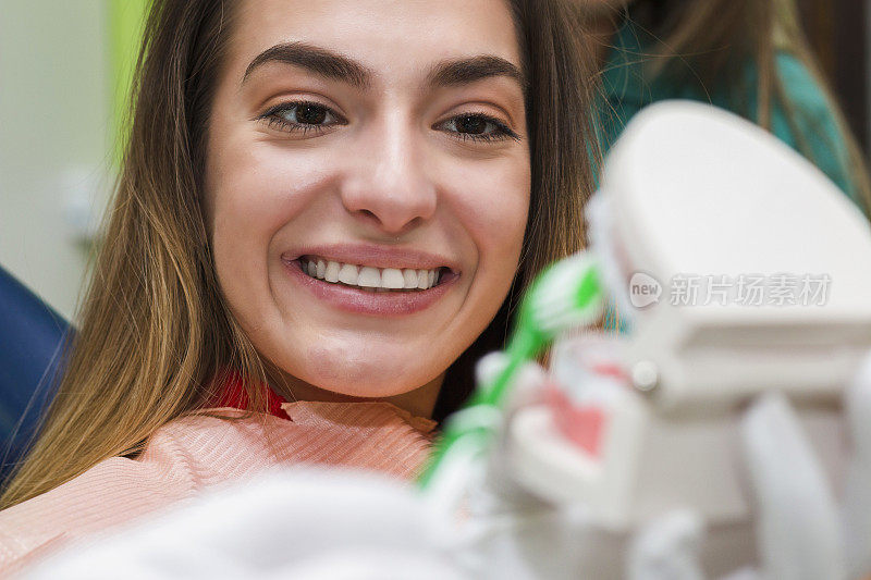 牙科医生在牙科诊所向病人展示牙颌模型