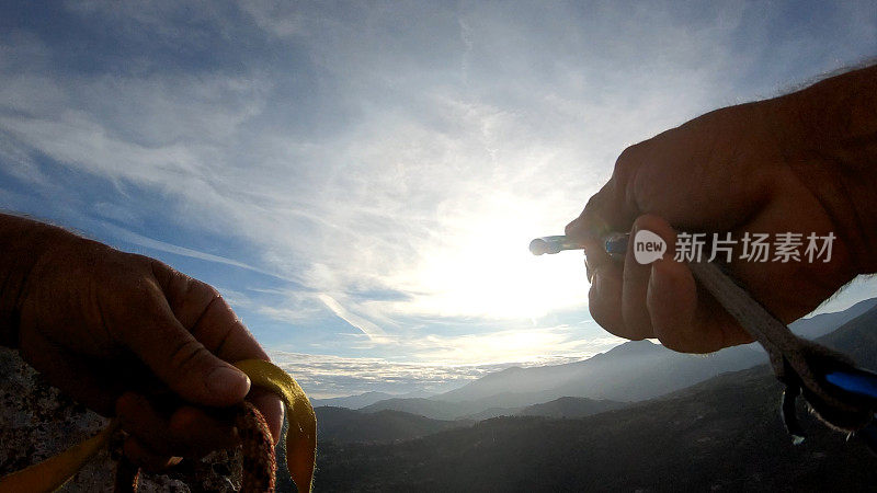 登山者在岩顶放置装备，以确保绳索安全