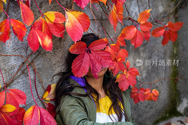 浪漫的秋天女人模型与棕色头发，与秋天时装女孩户外。秋天的女人在树叶的背景