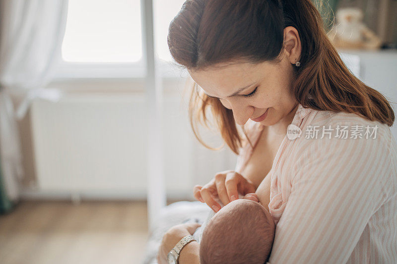 母亲在家里母乳喂养她的男婴