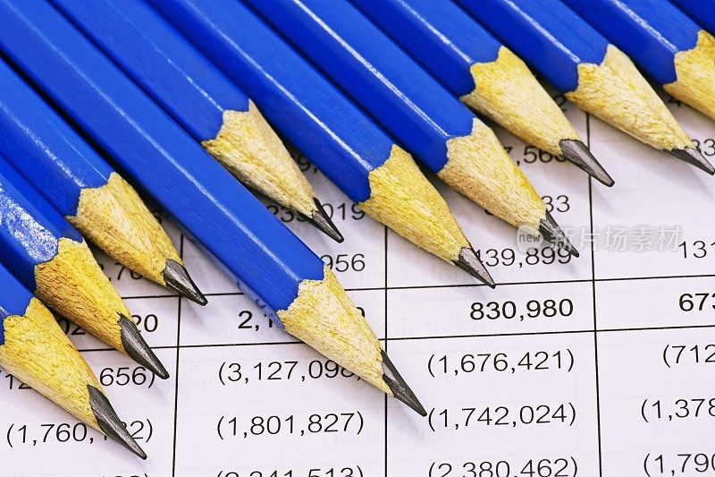 锋利的蓝色铅笔在财务报表上。