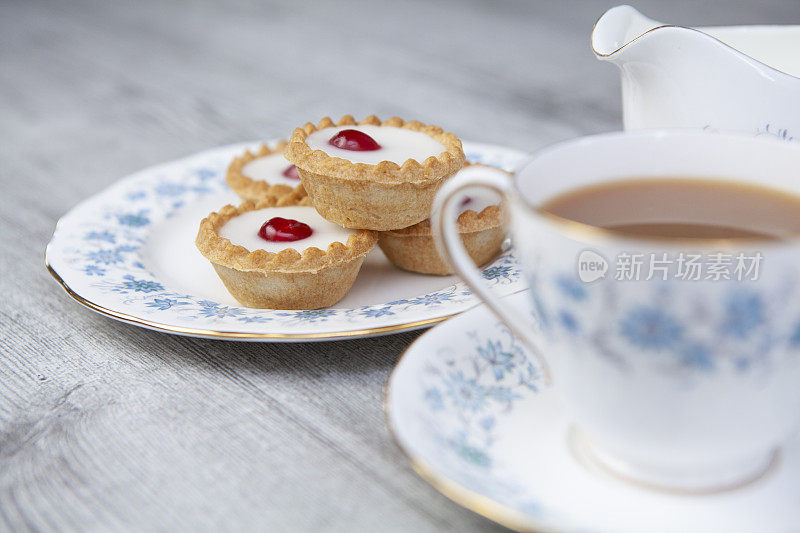 一杯茶和樱桃贝克威尔馅饼在一个轻木制表面