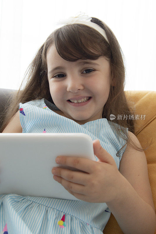 小女孩玩数码平板电脑玩得很开心