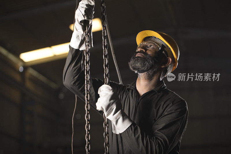 男工程师在工厂调整链葫芦