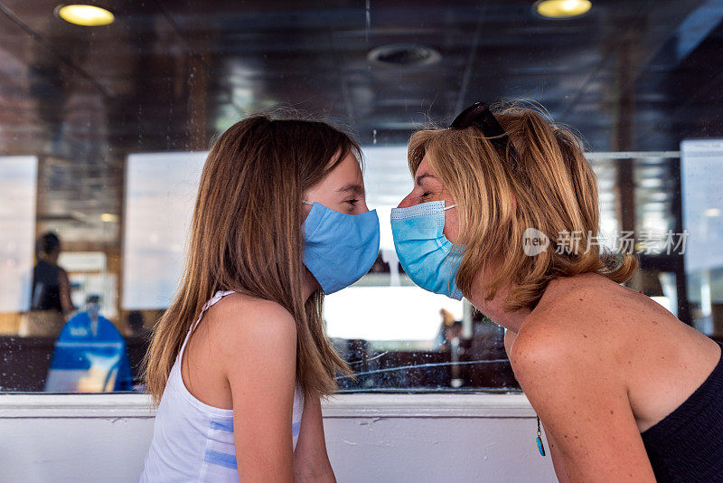 母亲和女儿戴着面具，在克罗地亚岛度假时乘坐渡船旅行