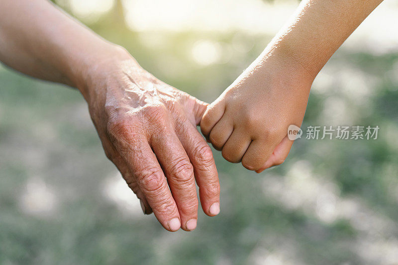 祖母和孩子手牵着手。爱的观念，家庭，保护孩子和老人，祖母，友谊，团聚