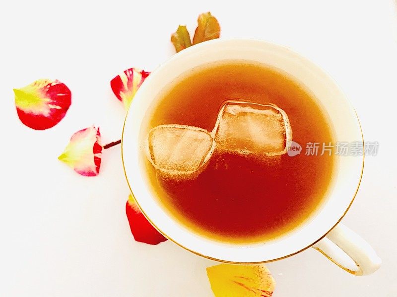 冰花草茶在一个杯子与玫瑰花瓣和叶子