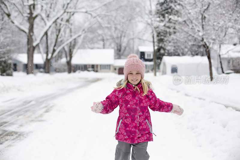 一个可爱的小女孩的肖像在雪地里奔跑