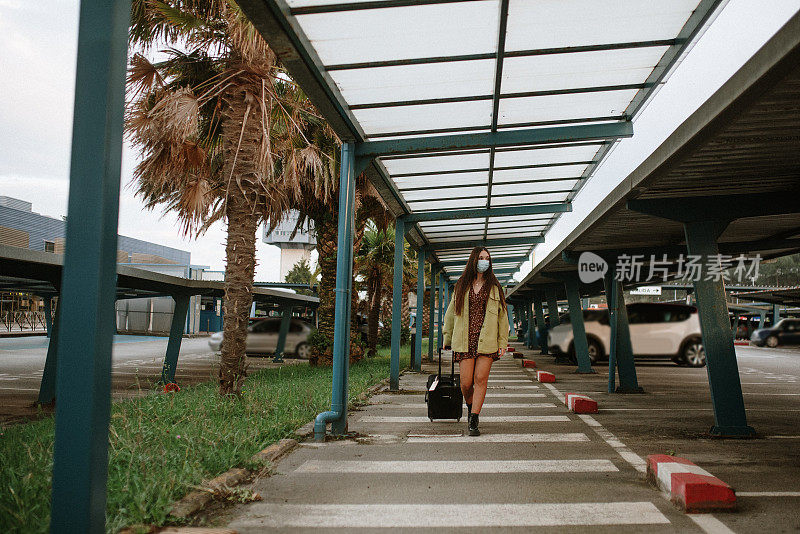 一名年轻女子在机场停车场戴着防护面罩