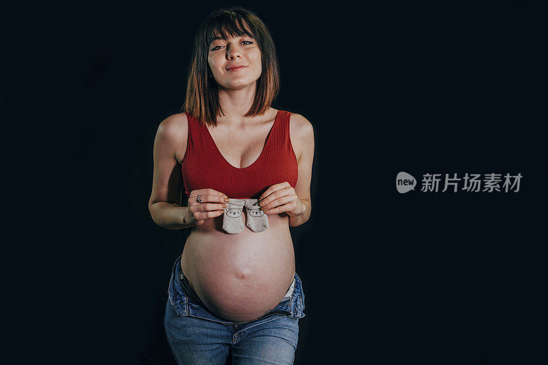 孕妇拿着一双婴儿袜