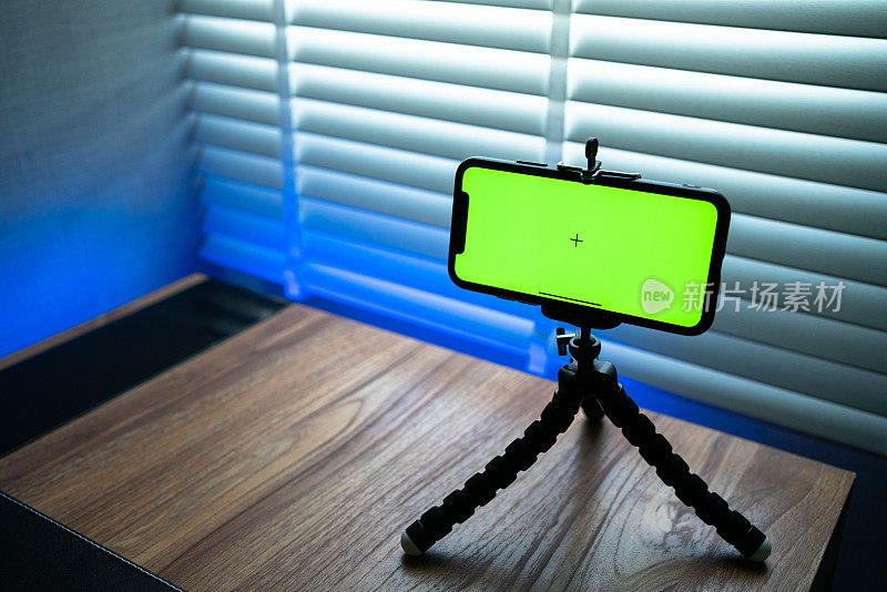 客厅的书桌上放着绿色色度按键屏幕的智能手机。