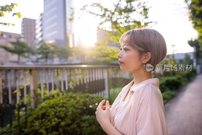 日落时分，一个年轻女子在河边看风景