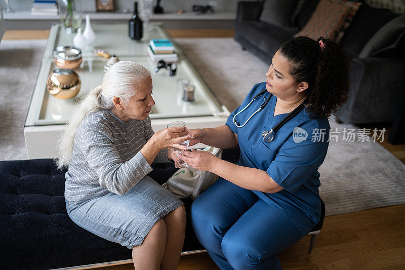 护士帮助老年妇女在家服药