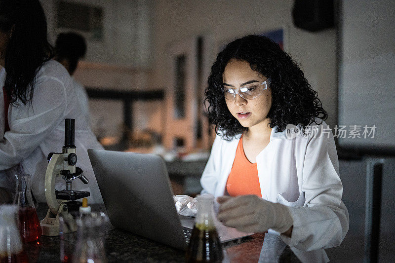 年轻女子在学校或大学里用笔记本电脑在实验室里学习