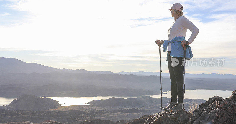 女徒步旅行者在阳光明媚的山脊上休息