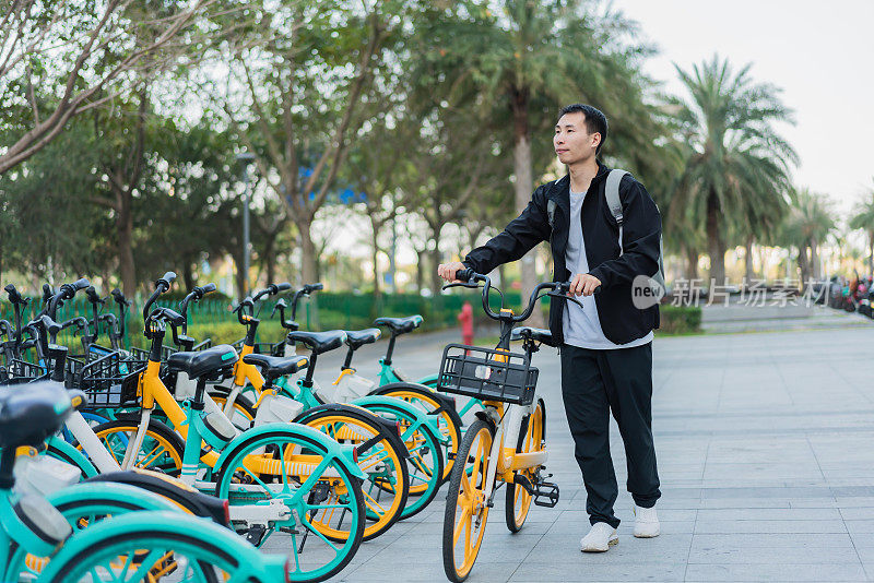 一名亚洲男子准备乘坐共享自行车旅行