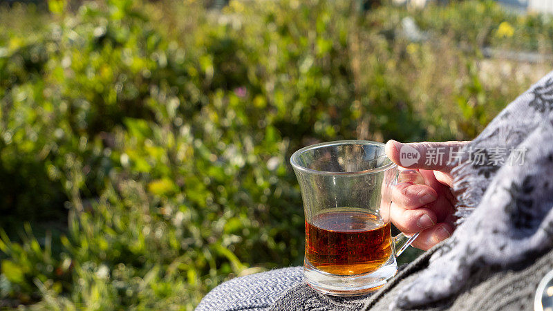 一个女人的手握着玻璃茶杯