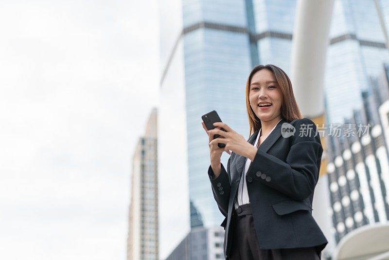 专业聪明酷的亚洲年轻漂亮的女商人微笑着在商业区使用电话