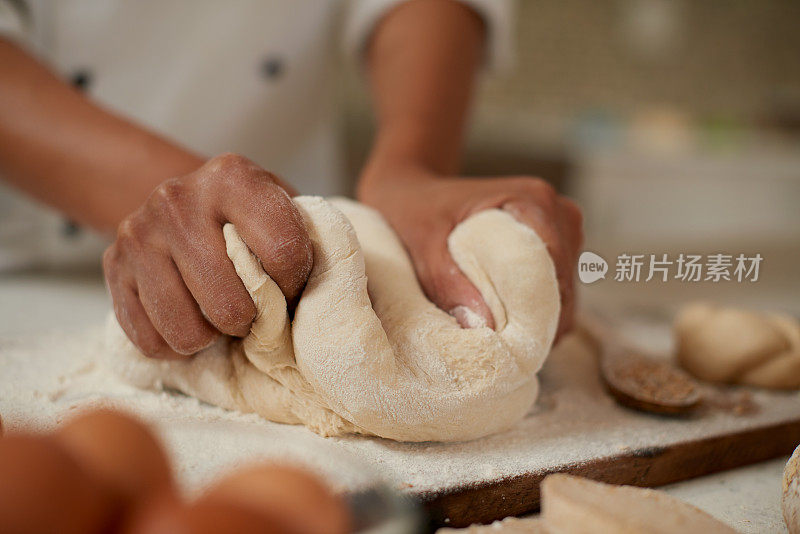 面包师准备在酒店烘焙的披萨面团。特写专业厨师用食谱制作和揉面团的手。在商业厨房烘焙和自制面包