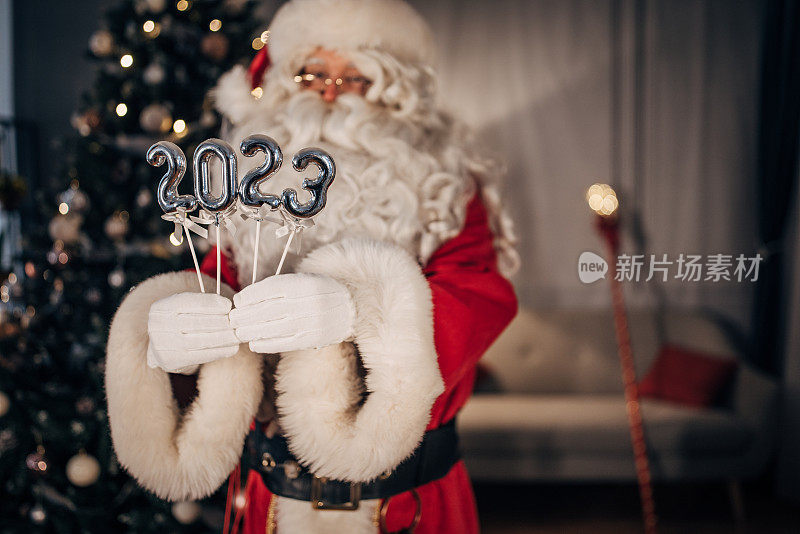 圣诞老人手持2023个新年和圣诞数字
