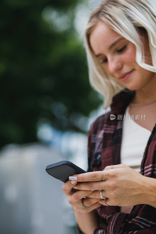 年轻女子使用智能手机上的出租车移动应用程序