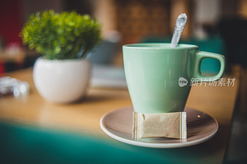 在餐馆的木桌上喝一杯茶