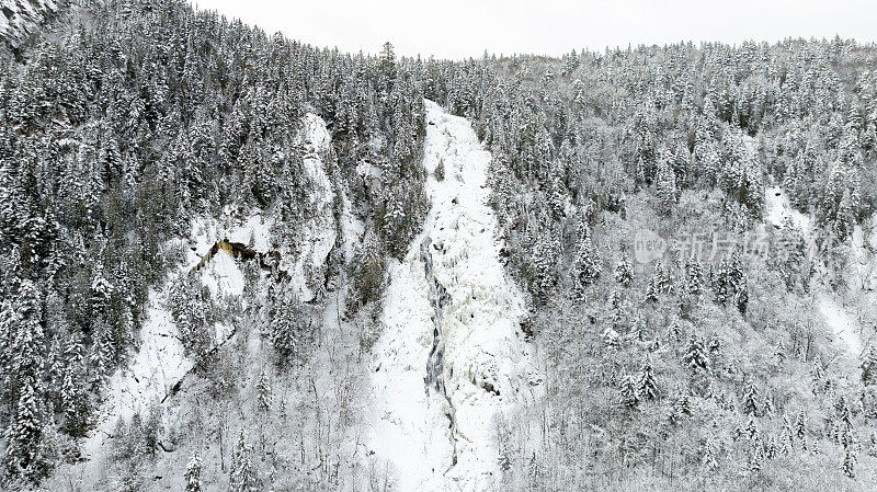 加拿大魁北克，暴风雪后冬季北方自然森林和河流的鸟瞰图