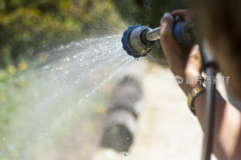 用软管喷嘴给花园浇水
