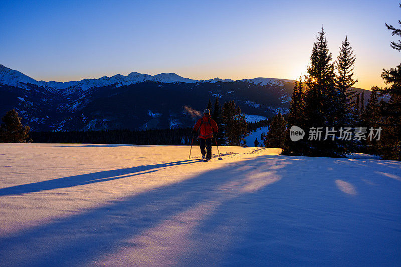 户外探险滑雪旅游与风景秀丽的山背景