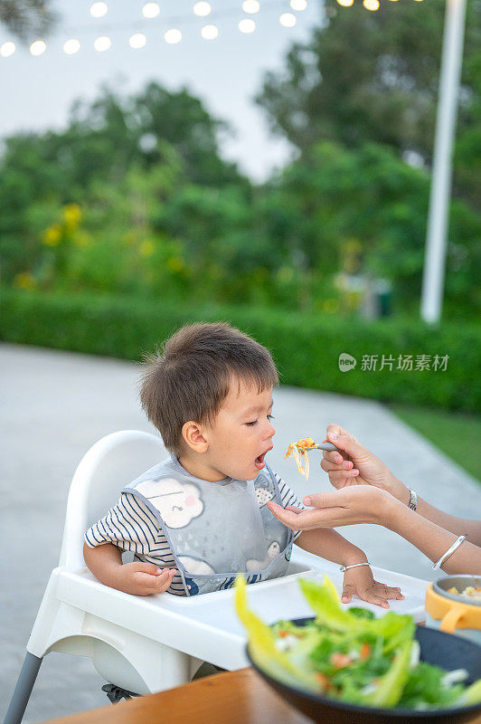 母亲在外面给她的男婴喂食