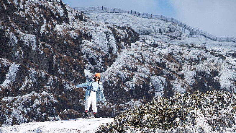 一个女人在寒冷的天气里穿行于白雪覆盖的山林之中