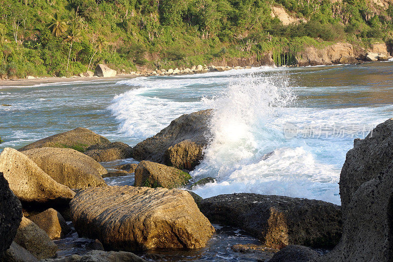 海浪拍击着海边的岩石。美丽的海滩景观在太平洋岛，东爪哇，印度尼西亚。