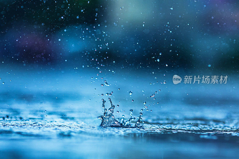 雨滴落在水坑里。下雨了。溅起的水