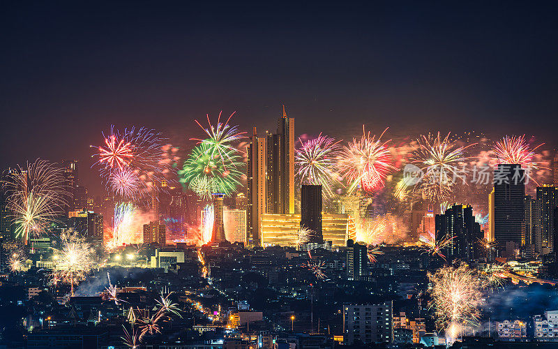 午夜时分，泰国曼谷市中心的一家百货商店和一座灯火通明的建筑上，燃放着新年烟花