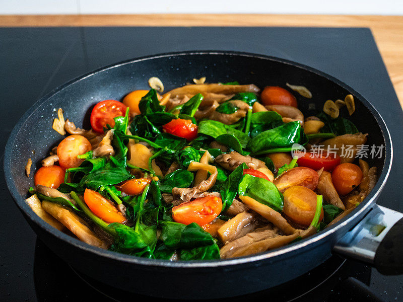 用煎锅煎菠菜和西红柿的平菇
