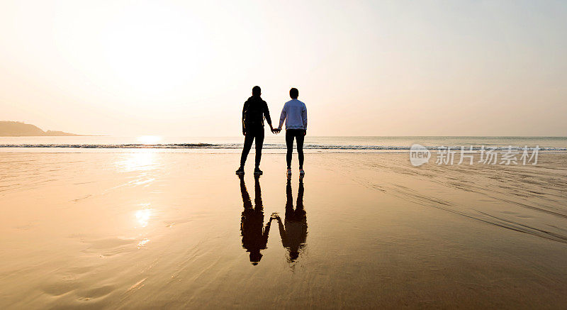 在海滩上牵手的情侣