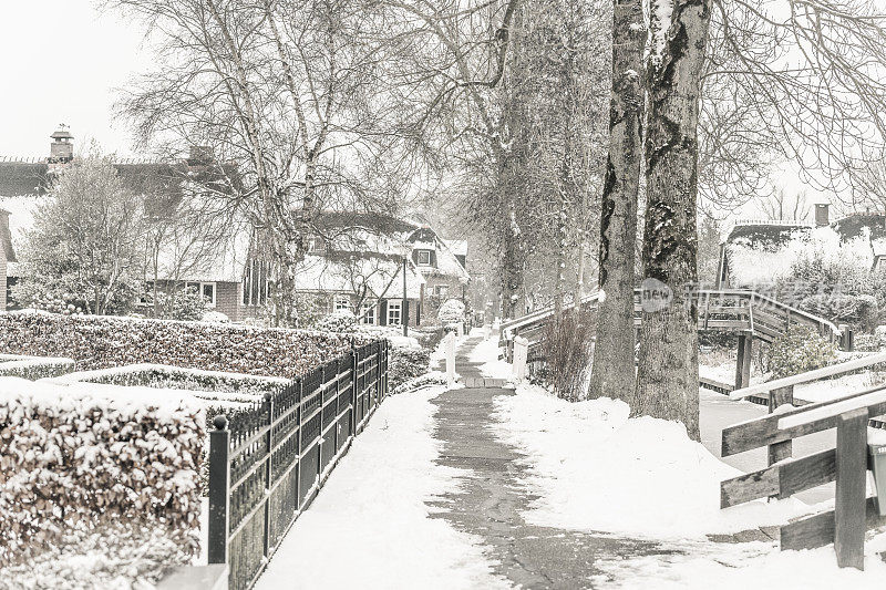 在一个寒冷但美丽而平静的冬天，Giethoorn村的运河和积雪