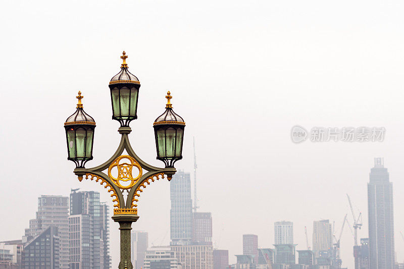 英国伦敦，威斯敏斯特桥上的路灯，背景是血色的摩天大楼