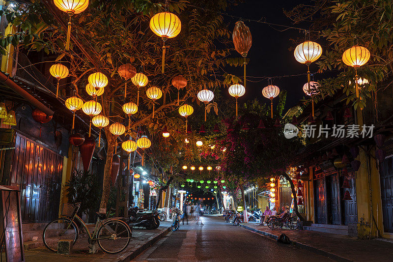 人们在会安老城河边的彩色餐厅休息。会安是越南中部岘港附近的城市，以保存完好的河边古镇而闻名